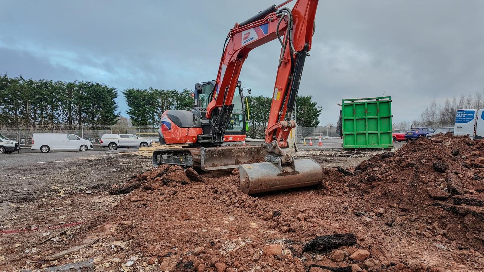 Excavator levelling ground for a hard standing