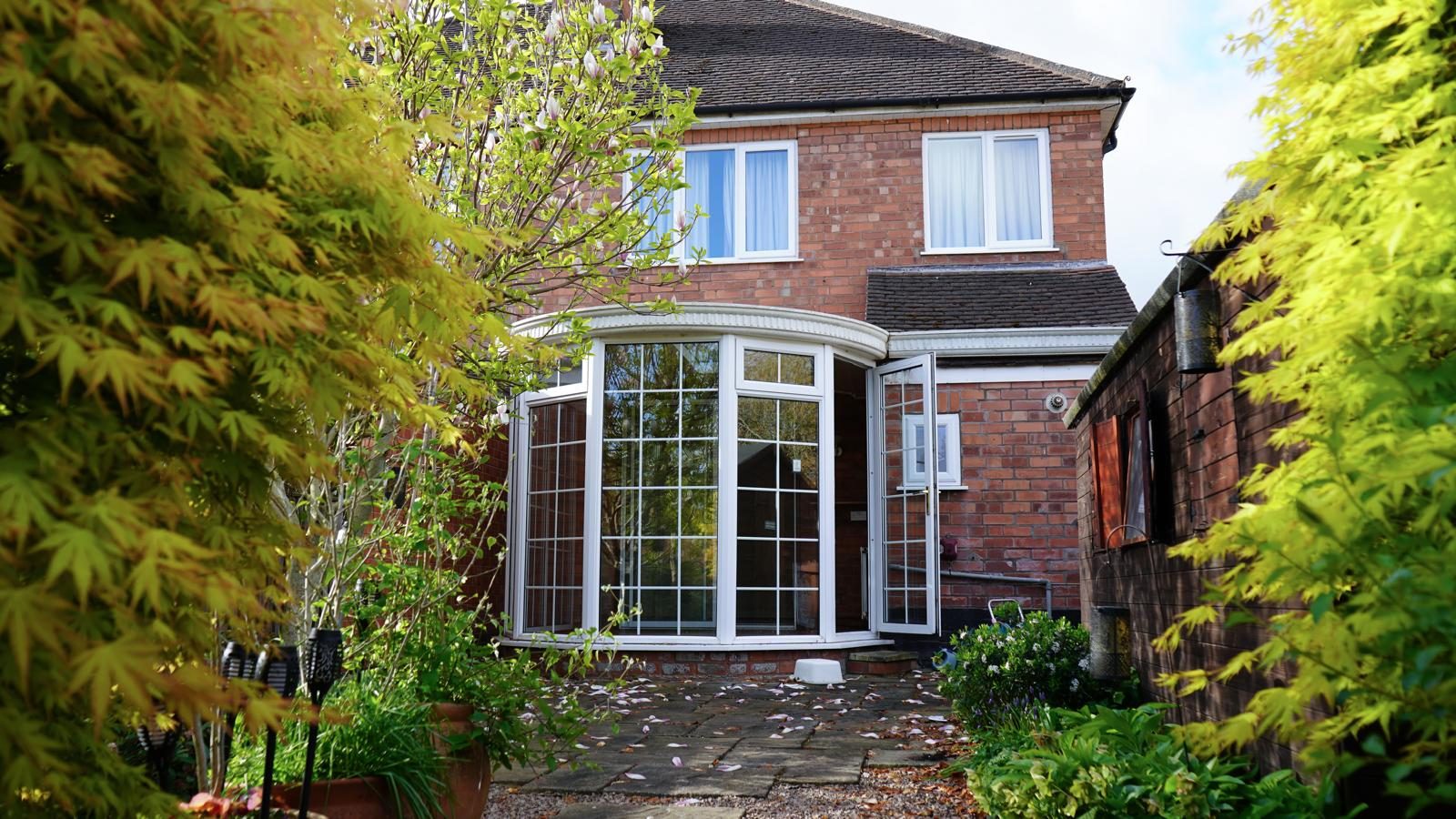 Rear of a brick house before a single-storey extension