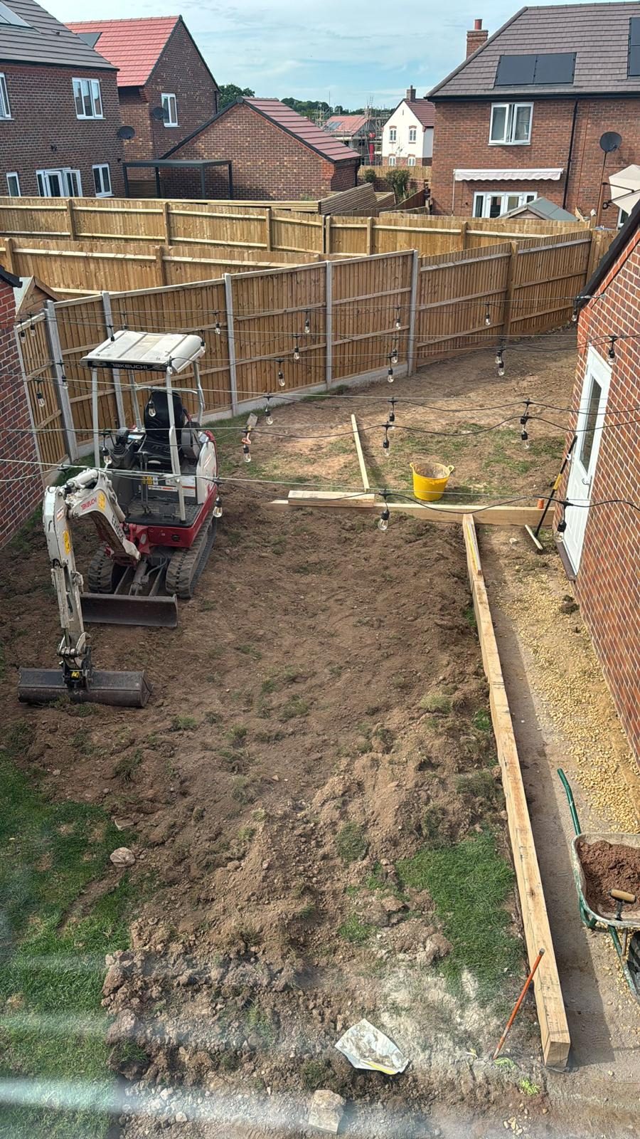 Mini digger levelling a new-build garden