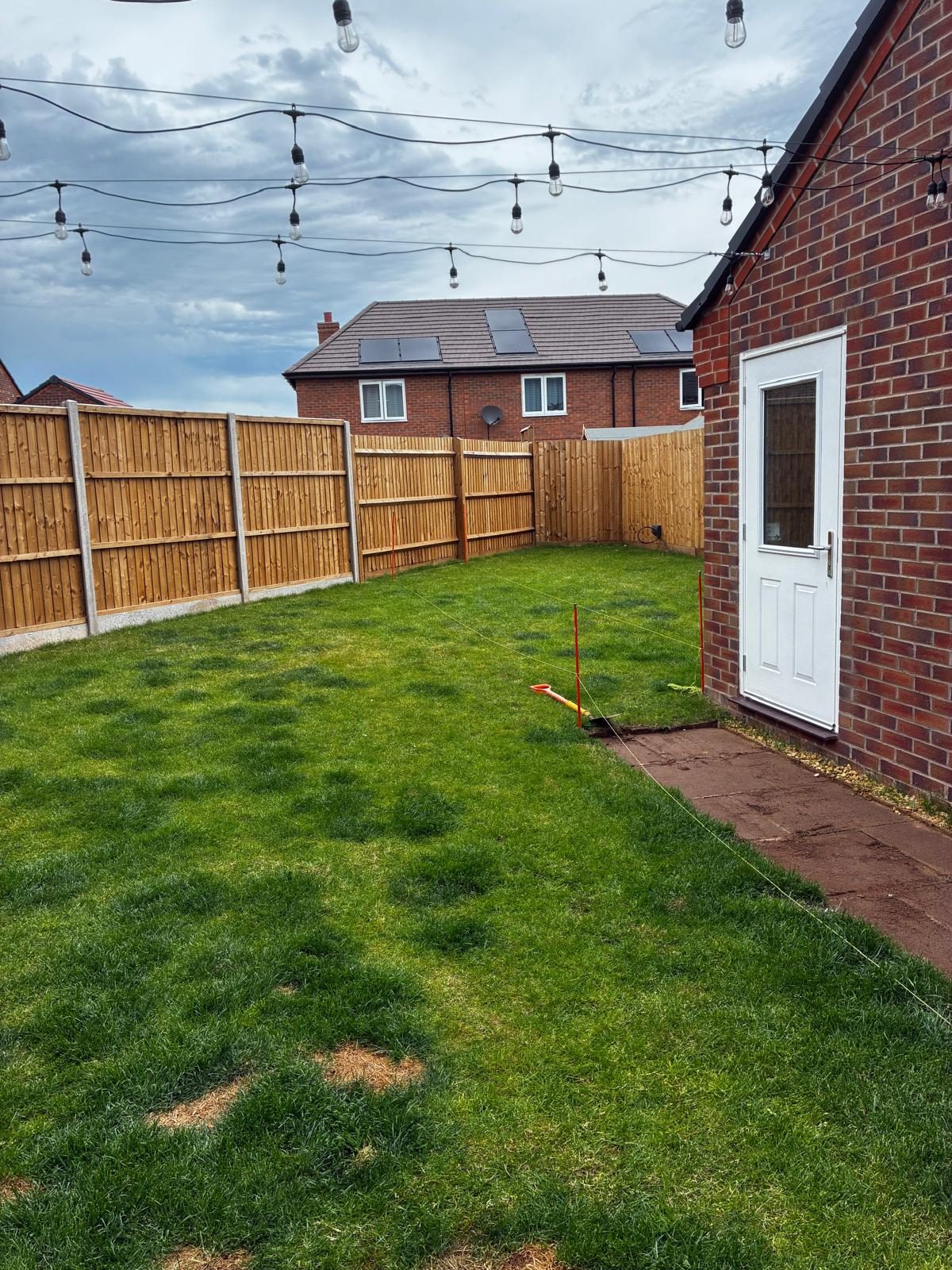 Landscaped garden with festoon lighting and new fencing