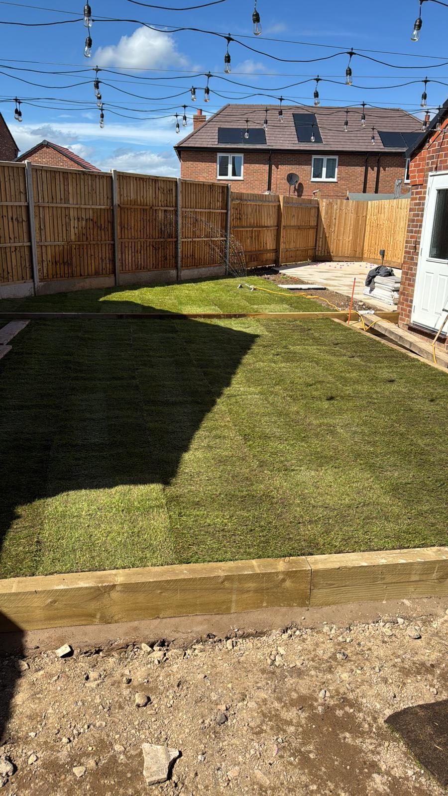 New turf being laid against sleeper edging