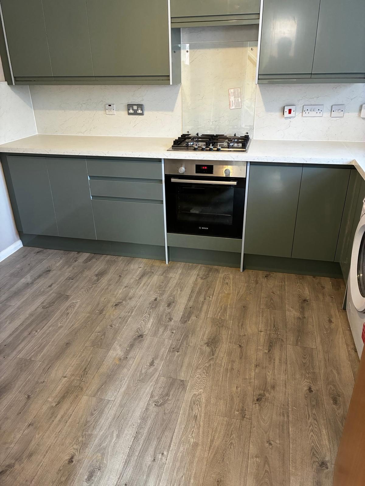 Sage green kitchen units with built-in oven