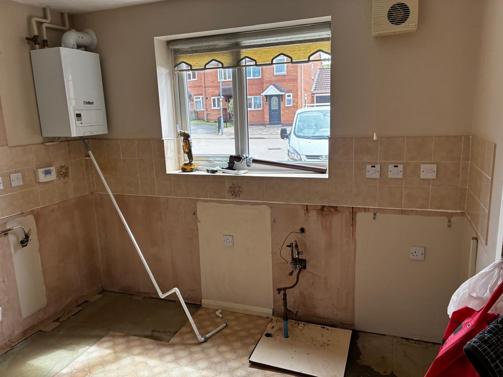 Stripped kitchen with pipework ready for new units
