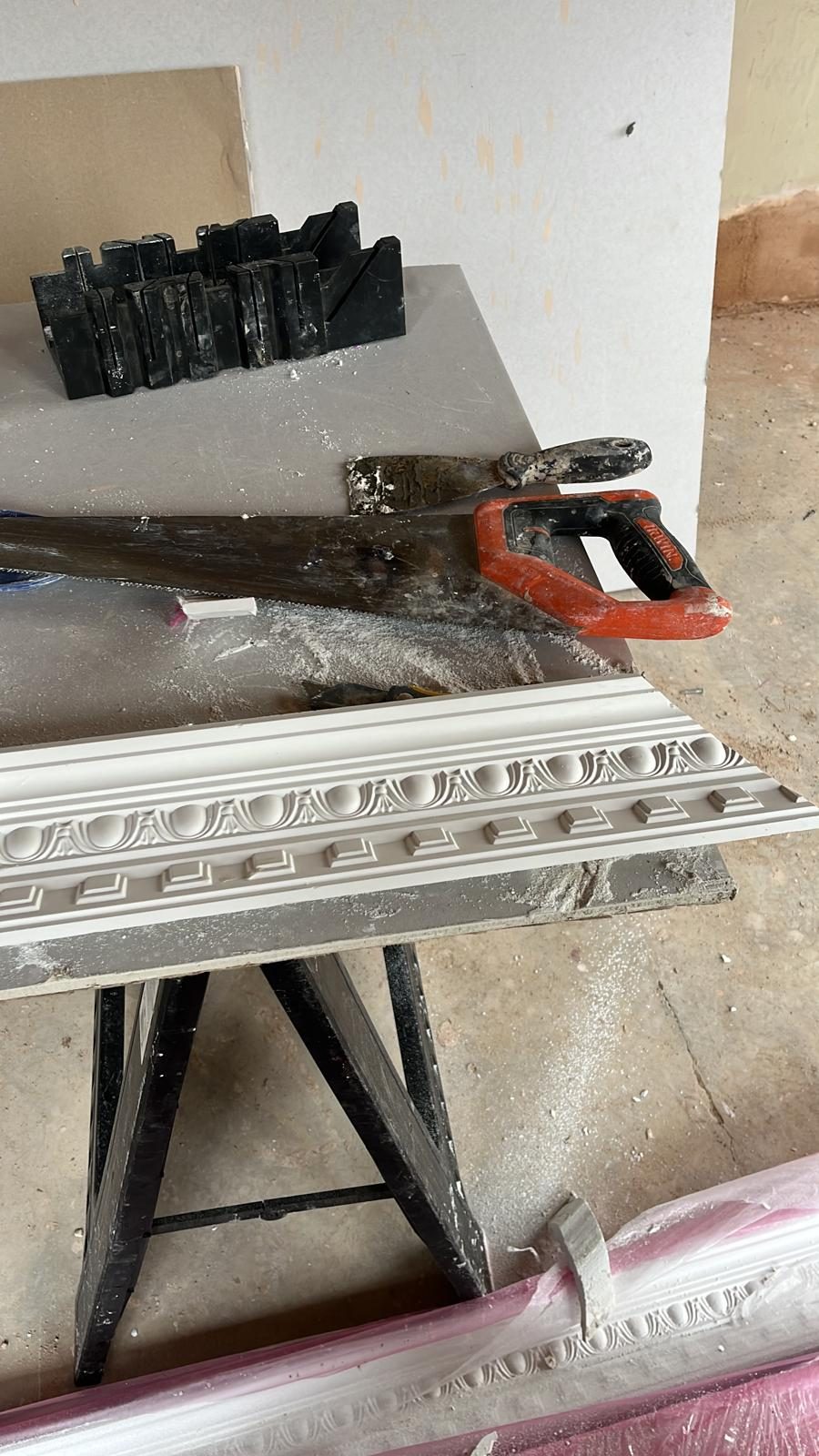 Plaster cornice being mitre-cut on a bench