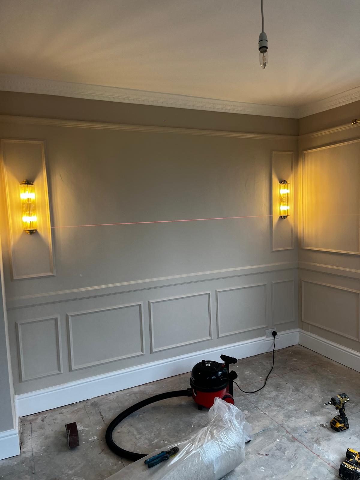 Laser level marking the picture rail line on panelled walls