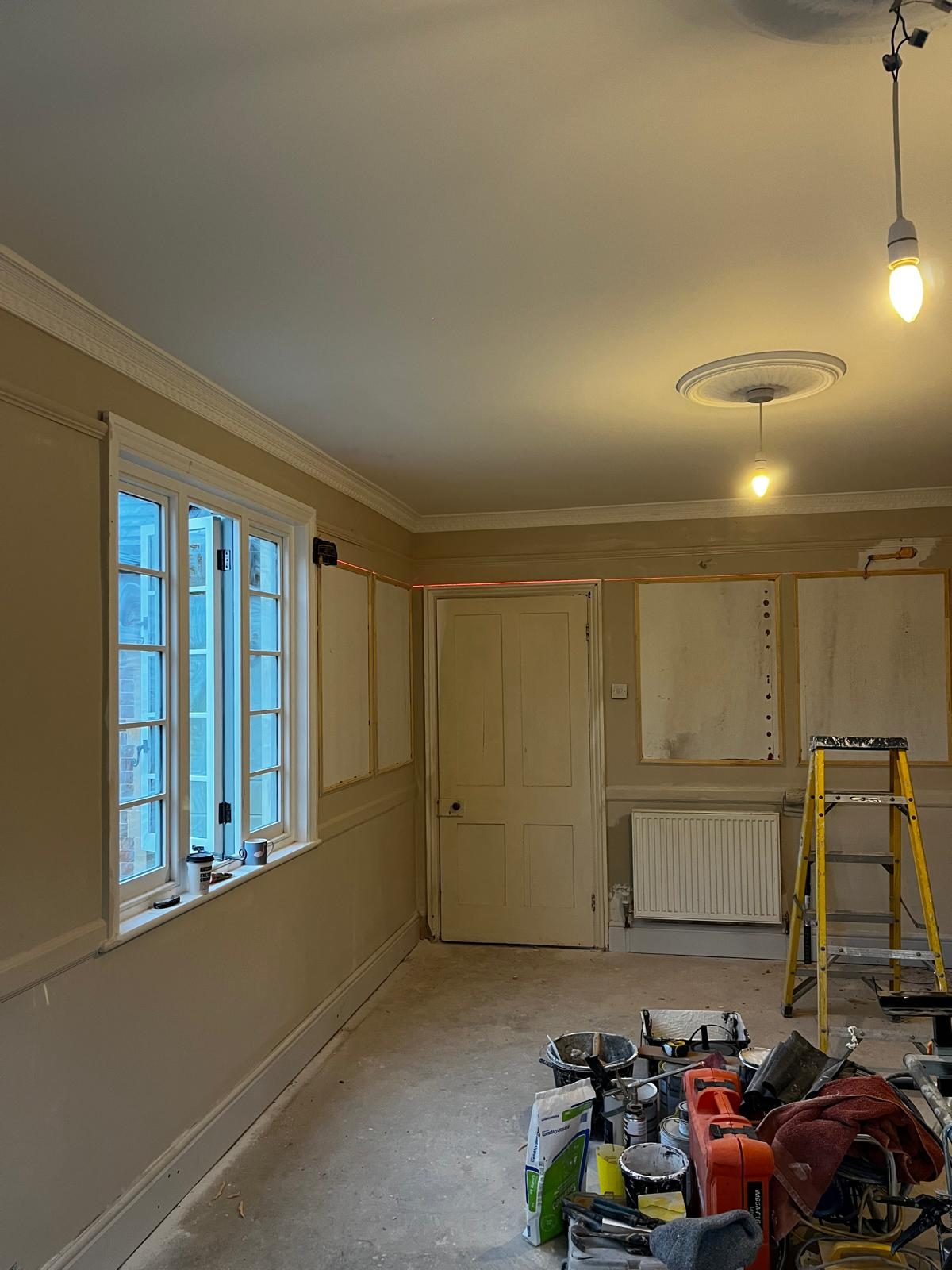 Wall panelling being fitted in a front room