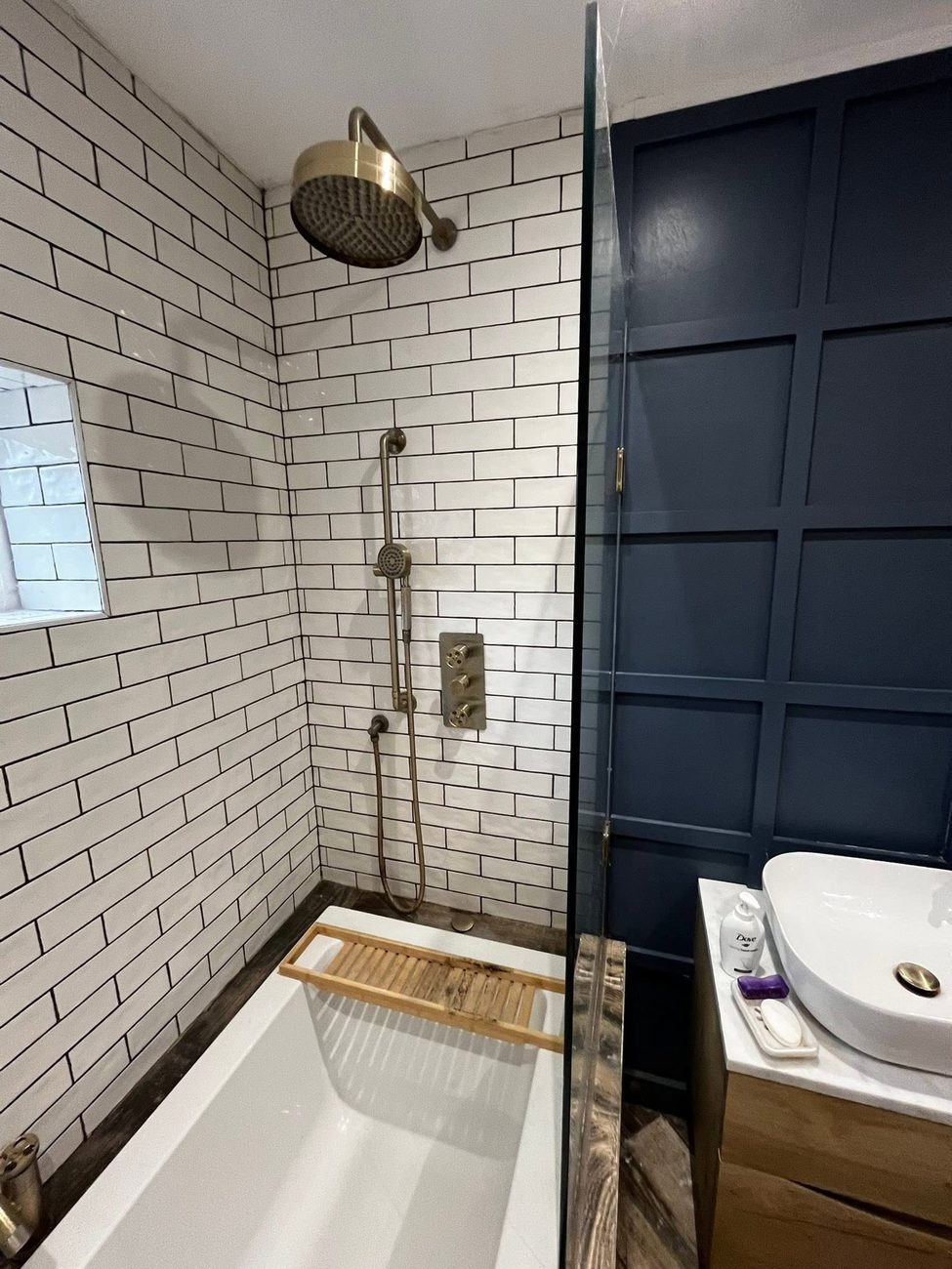 White metro tiled bathroom with brass shower
