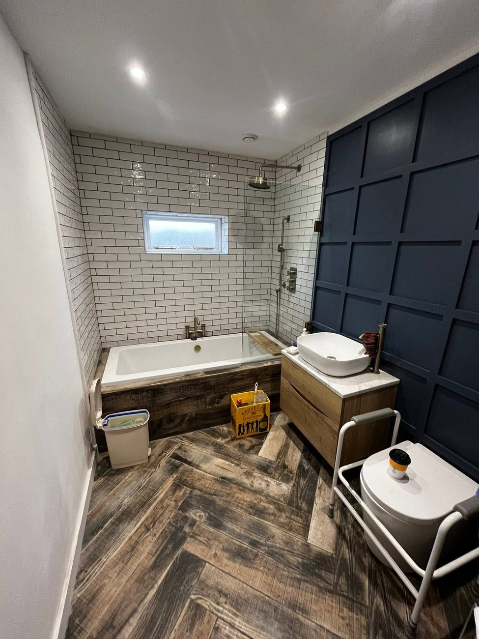 Navy panelled bathroom with herringbone floor